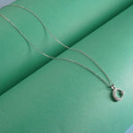 Sterling Silver necklace with moon star pendant on a green surface
