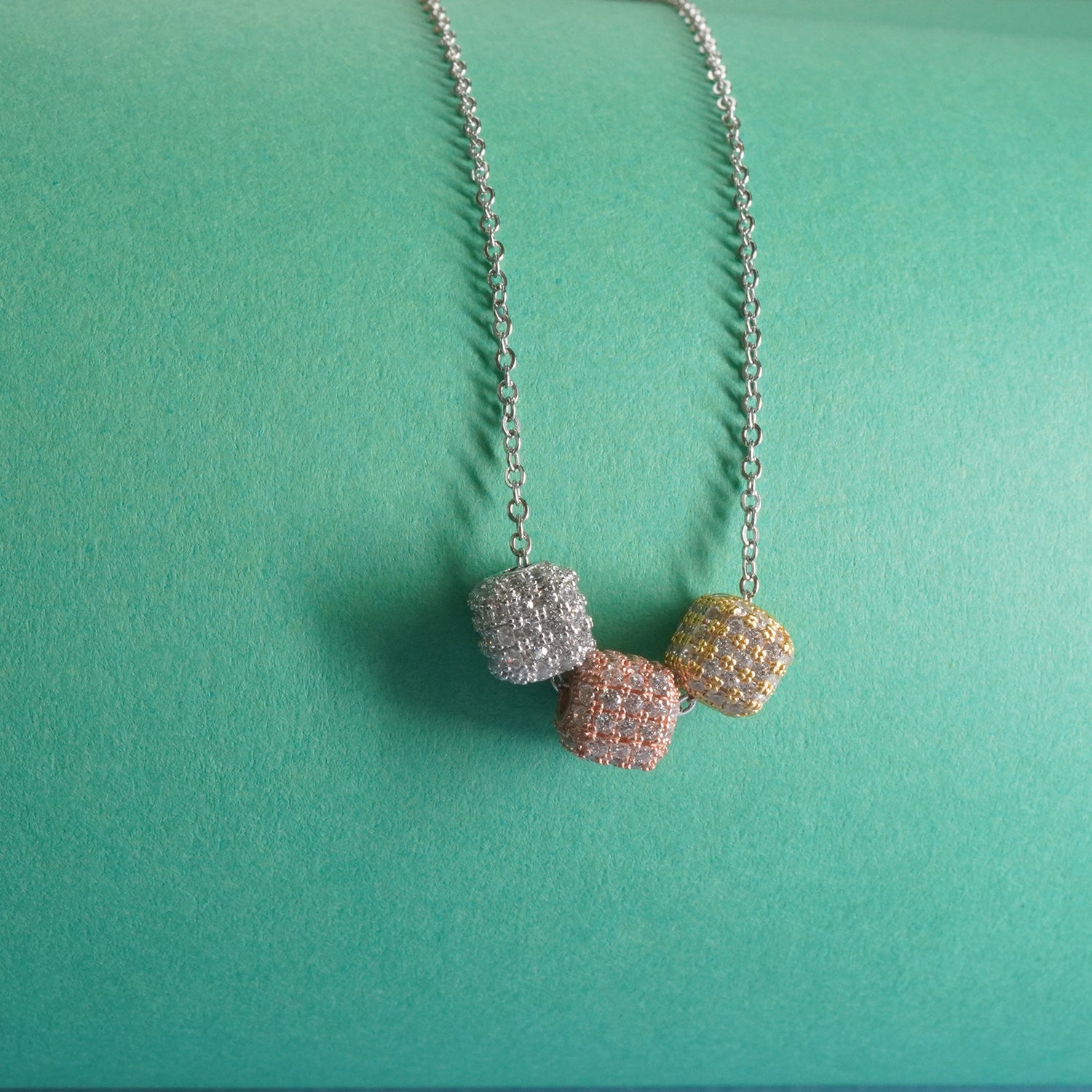 a close up of stone studded dice pendants made in sterling silver