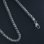 Close-up of intertwined engraved Cuban links in 925 silver chain

