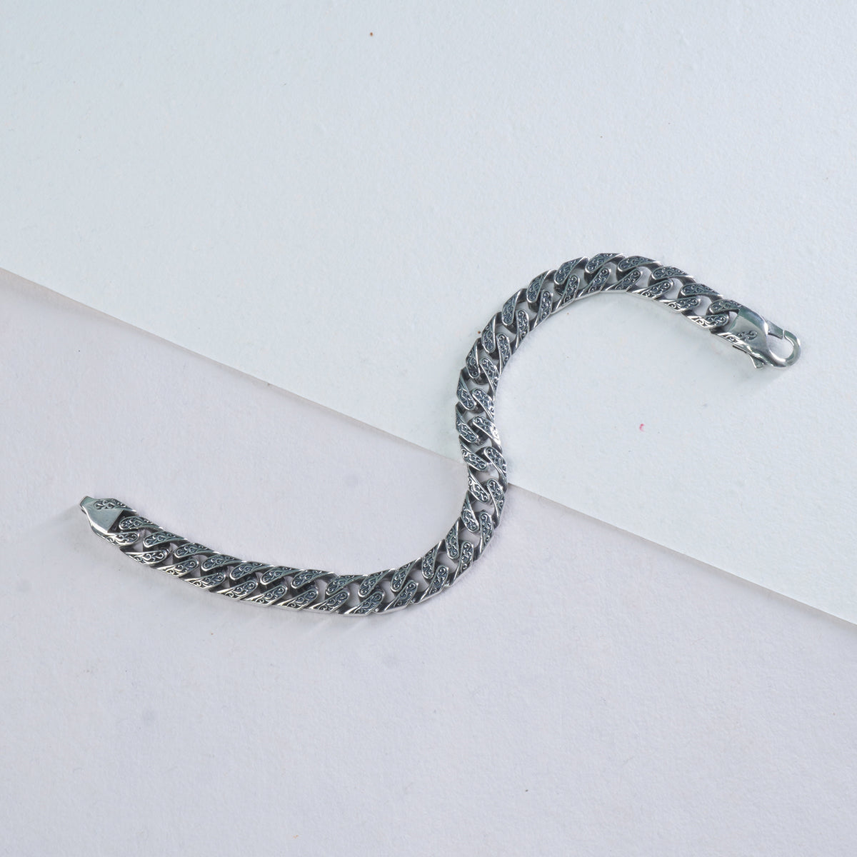 Silver chain bracelet on a light gray background