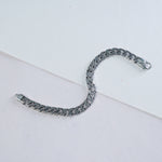Silver chain bracelet on a light gray background