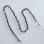 Silver mens chain necklace on a light gray background