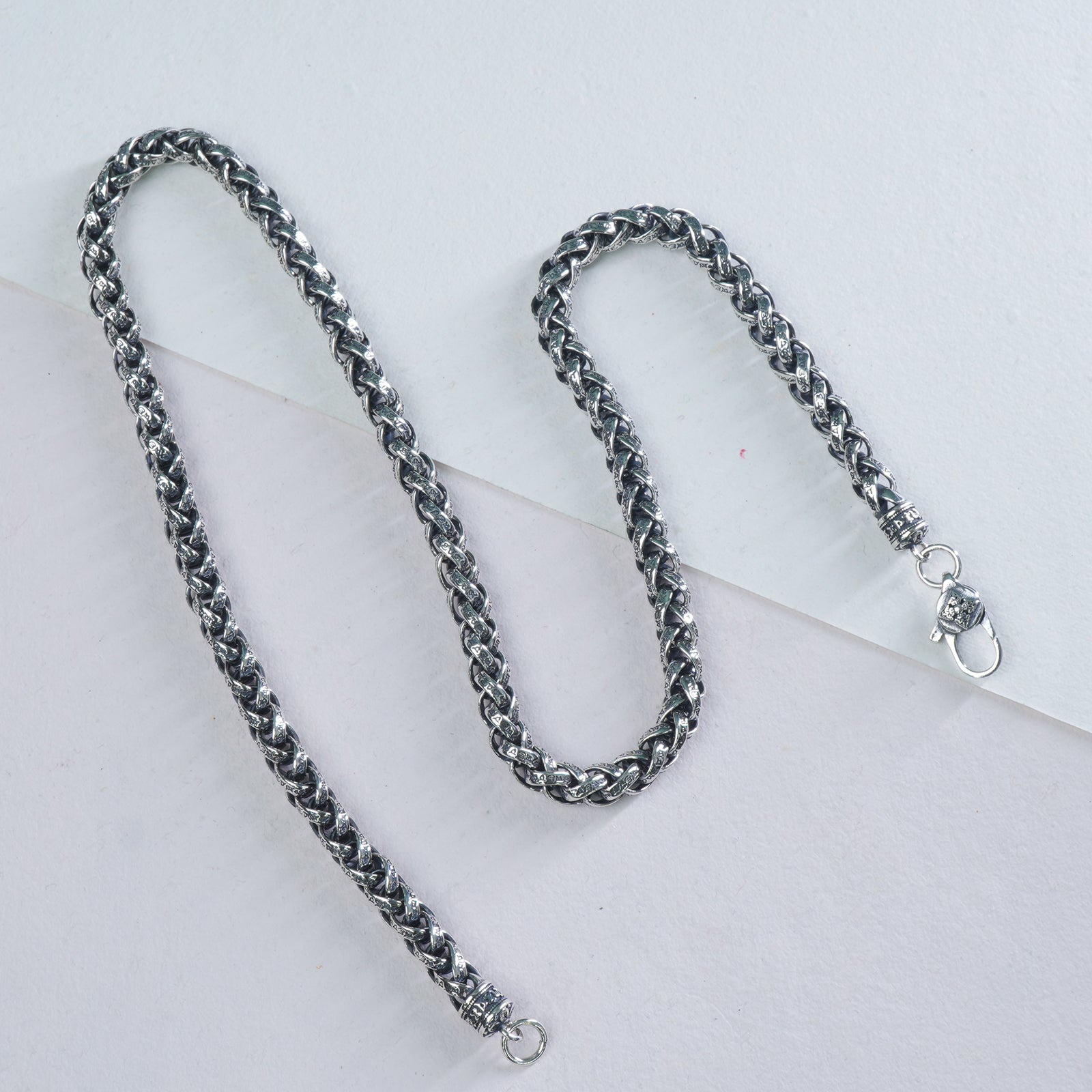 Silver mens chain necklace on a light gray background