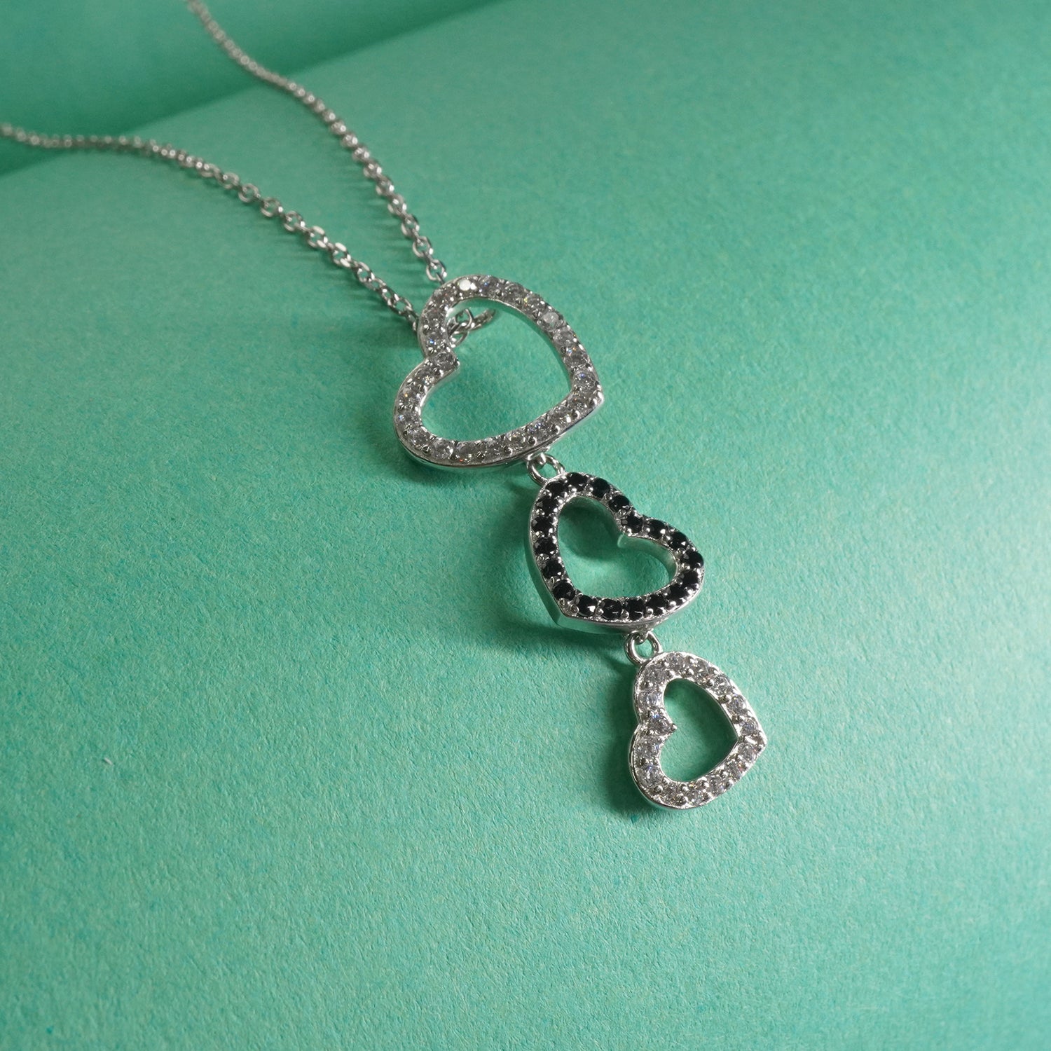 Indian Sterling Silver heart-shaped necklace on a teal background