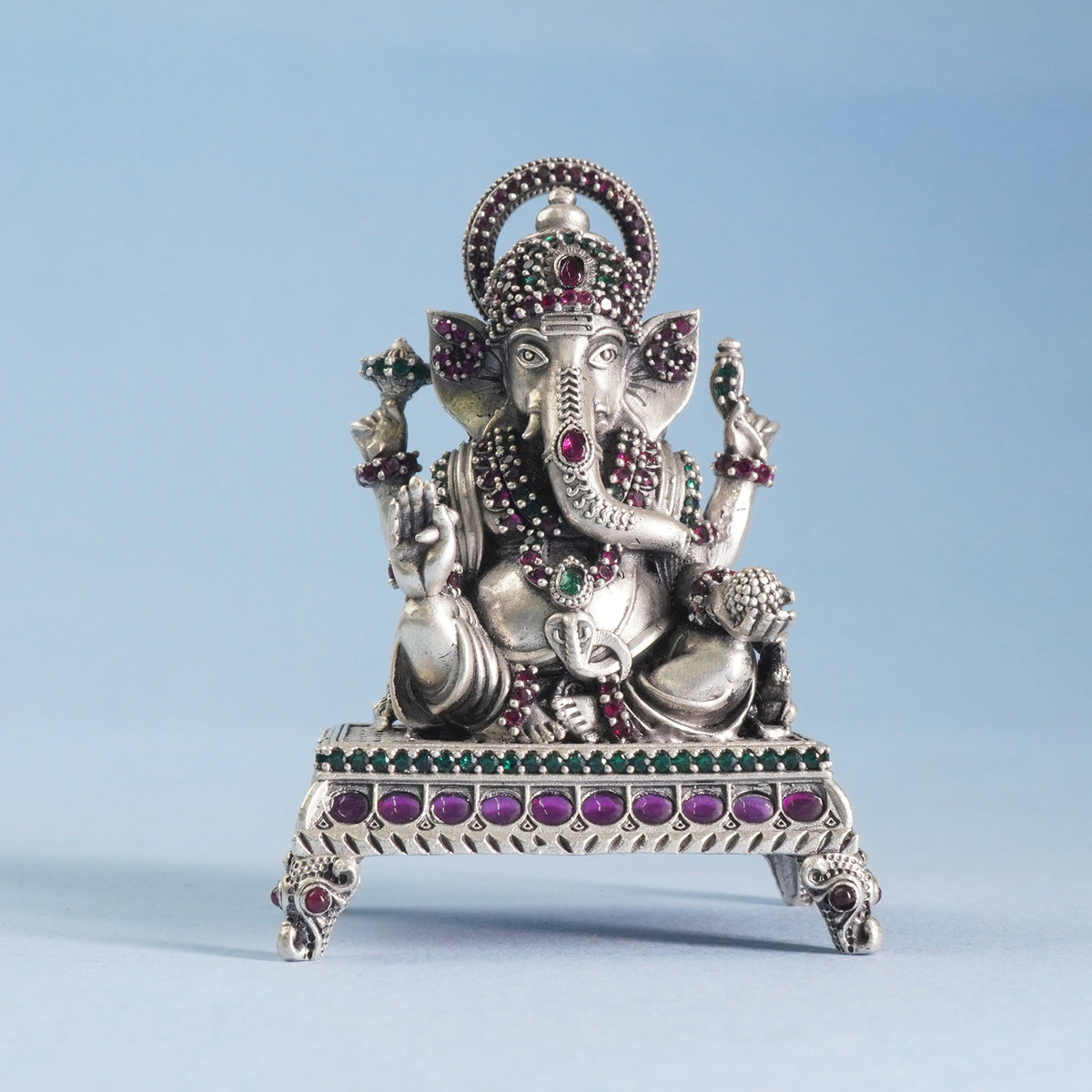 silver ganeshji idol on a blue background