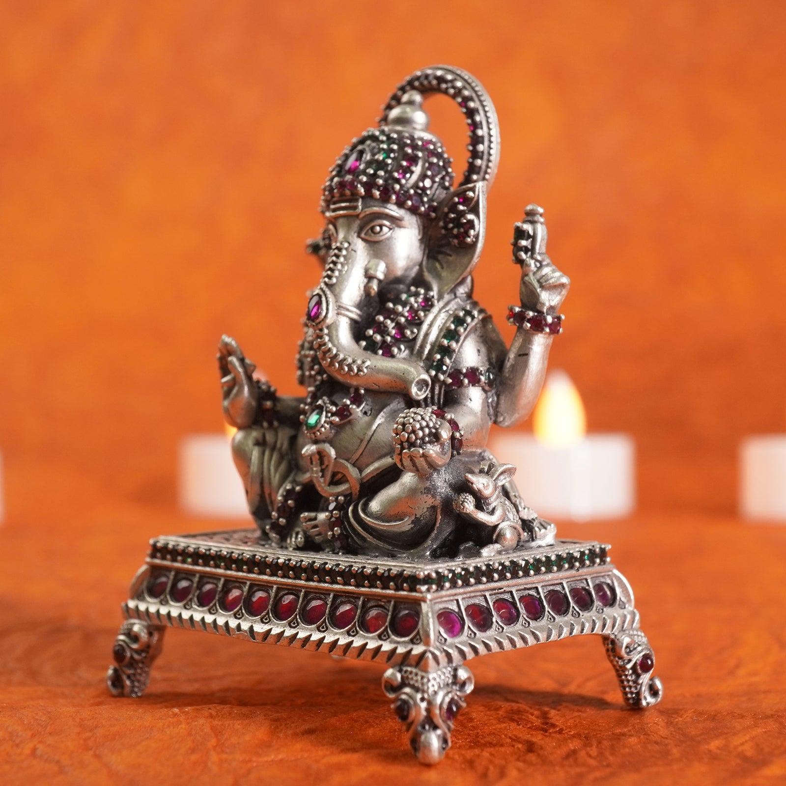 silver ganeshji murti on a orange background