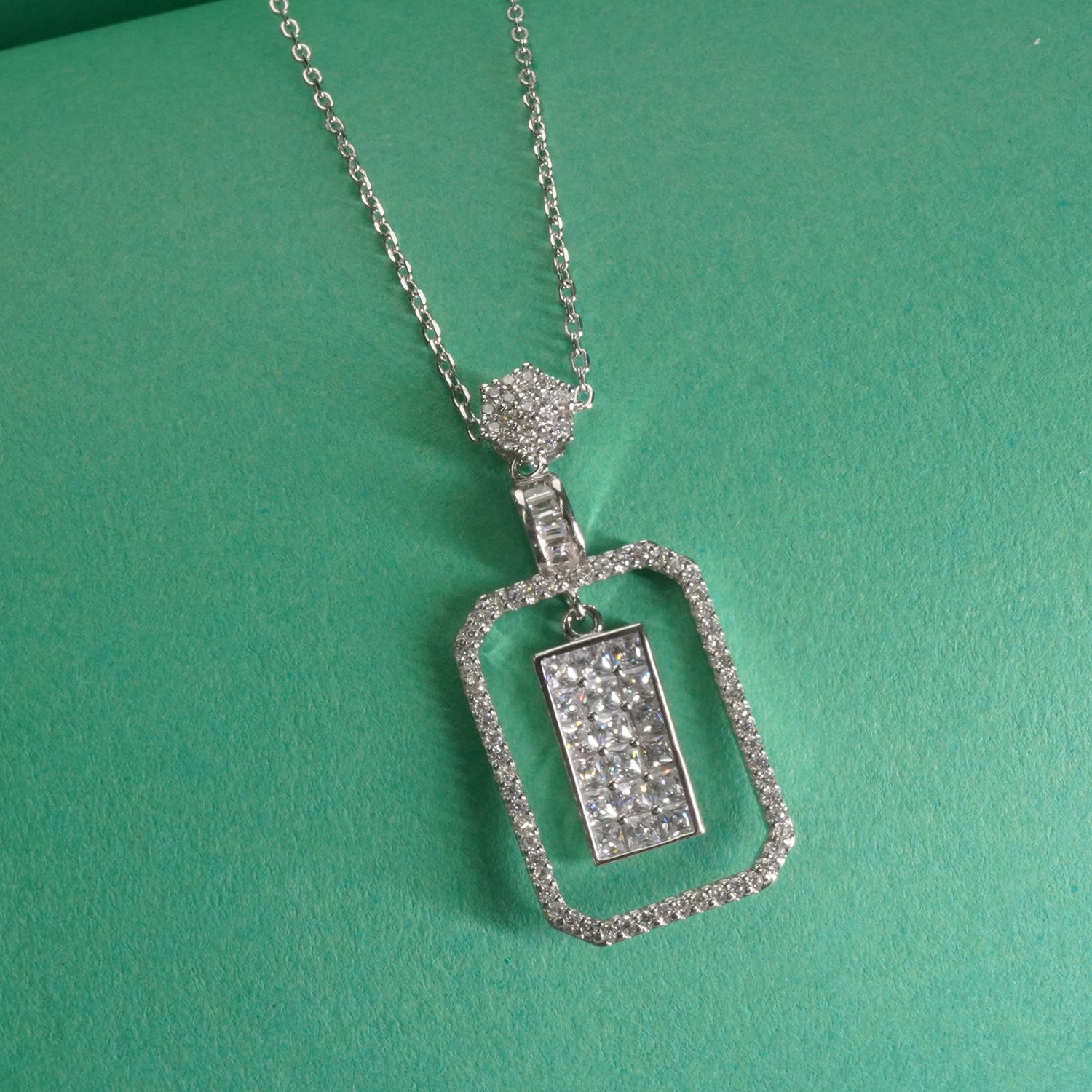 sterling Silver necklace with a rectangular pendant on a green background
